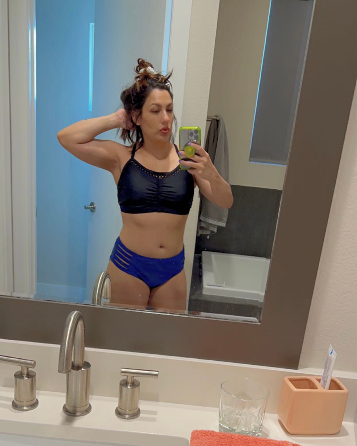 andrea valdez taking a selfie in her bathroom mirror to show her swimsuit