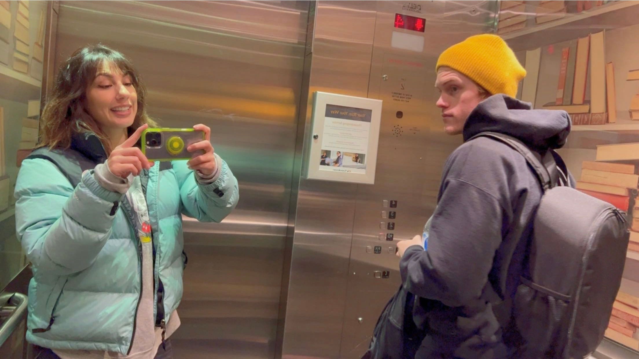 andrea valdez taking an elevator mirror selfie with brandon wells