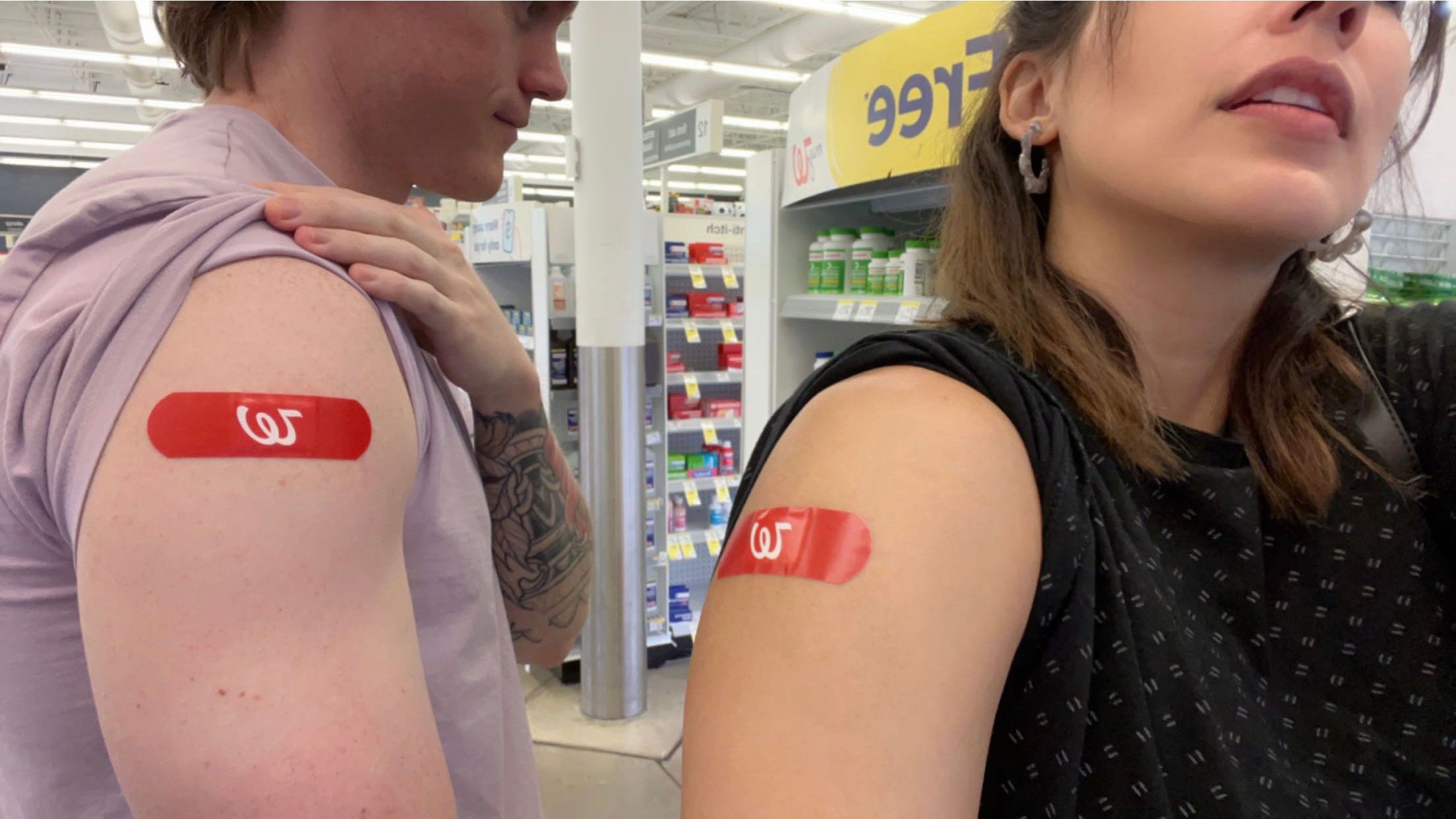 andrea valdez and brandon wells showing their arms with band aids from injections sites