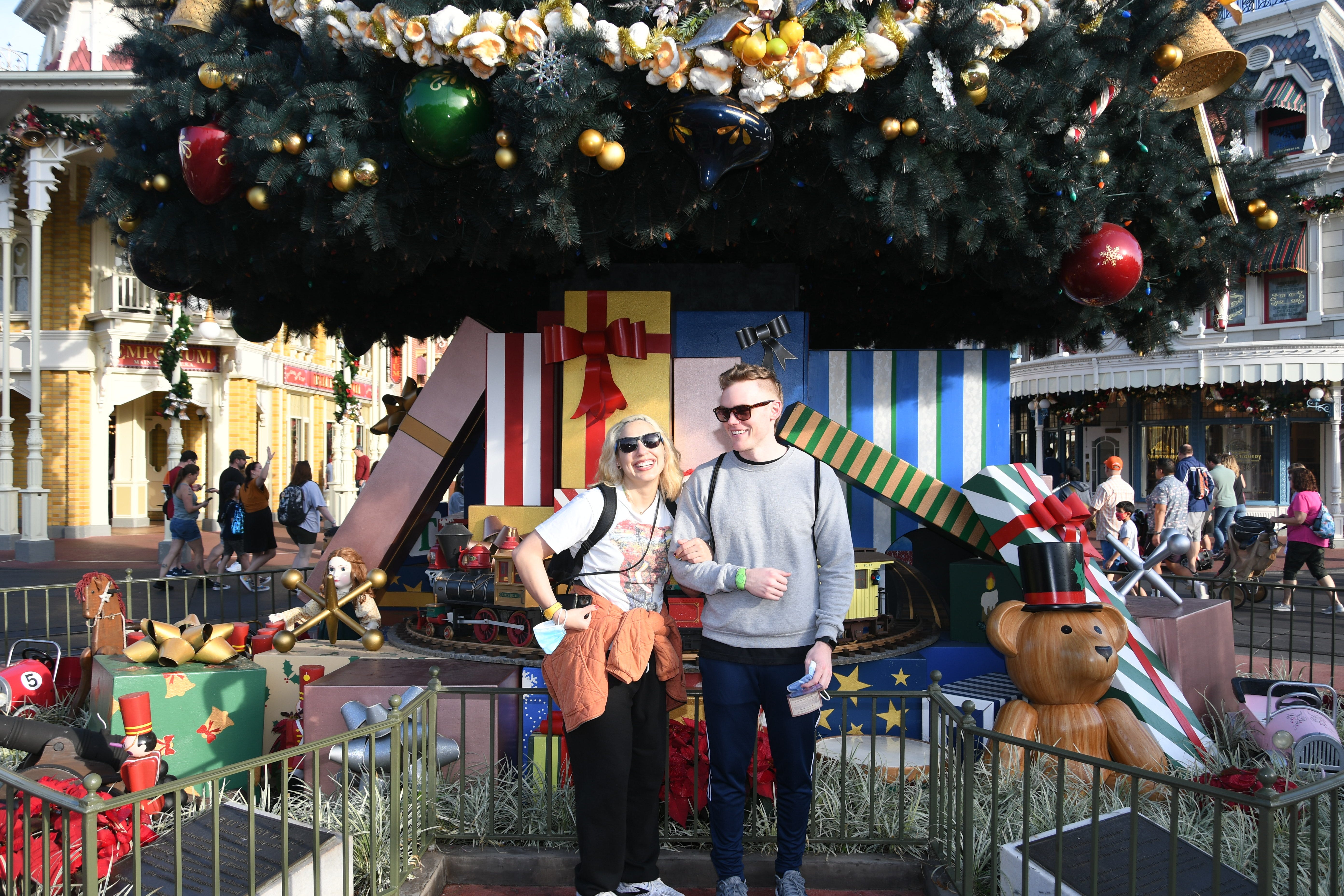 andrea valdez and brandon wells in front of a giant christmas tree at disney world