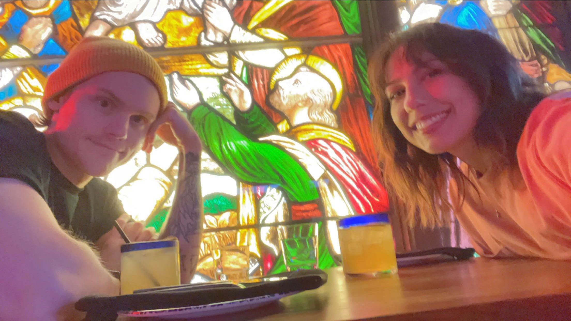 andrea valdez and brandon wells at a restaurant table taking a selfie